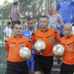 Sędzia główny spotkania Mateusz Kowalski (w środku) wyprowadza oba zespoły na boisko / Kamil Król / Radio Kielce