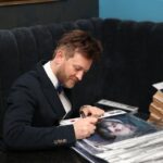 Paweł Stasiak – lider zespołu PapaD podpisuje Kalendarze Filantropa / Kamil Król / Radio Kielce