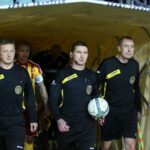 Sędzia główny spotkania Sebastian Jarzębak z Bytomia (w środku) wyprowadza oba zespoły na murawę boiska / Kamil Król / Radio Kielce