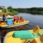 Świętokrzyskie na fali - Suchedniów. Dzieci pod opieką ratownika wybierają się na wodną wycieczkę rowerami wodnymi. / Wojciech Habdas / Radio Kielce