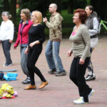 21.6.2015 Kielce. 1. Międzynarodowy Dzień Jogi. Przed muszlą koncertową kilkadziesiąt osób pod okiem instruktora wykonywało różne ćwiczenia. / Wojciech Habdas / Radio Kielce