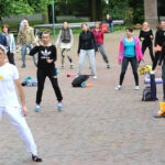 21.6.2015 Kielce. 1. Międzynarodowy Dzień Jogi. Przed muszlą koncertową kilkadziesiąt osób pod okiem instruktora wykonywało różne ćwiczenia. / Wojciech Habdas / Radio Kielce