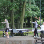 21.6.2015 Kielce. 1. Międzynarodowy Dzień Jogi. Przed muszlą koncertową kilkadziesiąt osób pod okiem instruktora wykonywało różne ćwiczenia. Nie odstraszył ich padający przelotnie deszcz. / Wojciech Habdas / Radio Kielce