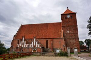 30.07.2015 Green Velo. Warmińsko-Mazurskie. Kościół w Barcianach, malwy przy tym kościele / Krzysztof Żołądek / Radio Kielce