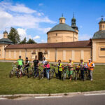 29.7.2015 Lidzbark Warmiński. Z lokalną grupą rowerzystów wybraliśmy się na wycieczkę fragmentem szlaku Green Velo prowadzącym do Stoczka Klasztornego. U celu podróży w Stoczku, pamiątkowe zdjęcie uczestników wycieczki. W tle zespół klasztorny księży Marianów (dawniej Bernardynów) oraz Kościół p.w. Nawiedzenia N.P. Maryi. Zabytek uznany na Warmii za jeden z najcenniejszych i po św. Lipce największy, ze względu na architekturę jak i wyposażenie wnętrza, zespół odpustowy. / Wojciech Habdas / Radio Kielce
