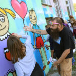 13.9.2015 Kielce. Mural ozdobił ścianę Specjalistycznego Ośrodka Wsparcia dla Ofiar Przemocy w Rodzinie w Kielcach. W malowaniu pomagał artysta graffiti Dariusz Paczkowski, który maluje murale od ponad 30. lat. / Wojciech Habdas / Radio Kielce