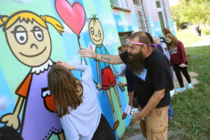 13.9.2015 Kielce. Mural ozdobił ścianę Specjalistycznego Ośrodka Wsparcia dla Ofiar Przemocy w Rodzinie w Kielcach. W malowaniu pomagał artysta graffiti Dariusz Paczkowski, który maluje murale od ponad 30. lat. / Wojciech Habdas / Radio Kielce