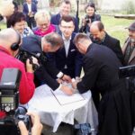 Wicestarosta Eligiusz Mich, prezydent Ostrowca Świętokrzyskiego Jarosław Górczyński i ks. Adam Gucwa wypełniają kapsułę czasu / Emilia Sitarska / Radio Kielce