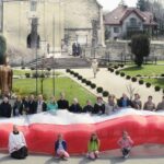 Skalbmierz. Mieszkańcy pozują do zdjęcia z prawie 30-metrową flagą / Karolina Kula