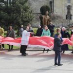 Skalbmierz. Mieszkańcy pozują do zdjęcia z prawie 30-metrową flagą / Karolina Kula