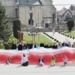 Skalbmierz. Mieszkańcy pozują do zdjęcia z prawie 30-metrową flagą / Karolina Kula