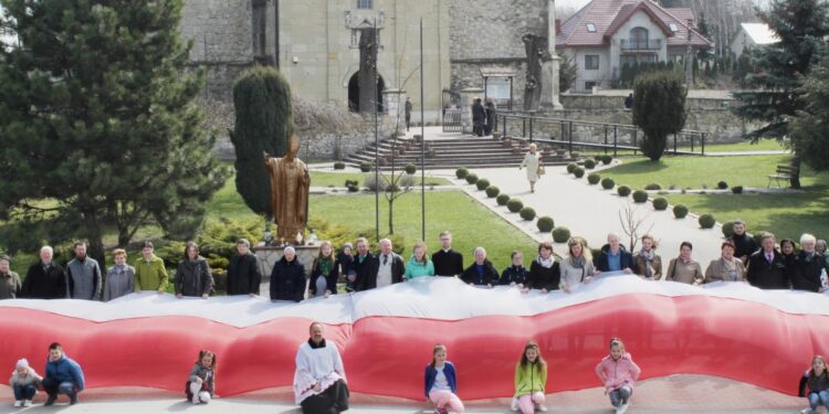 Skalbmierz. Mieszkańcy pozują do zdjęcia z prawie 30-metrową flagą / Karolina Kula