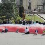 Skalbmierz. Mieszkańcy pozują do zdjęcia z prawie 30-metrową flagą / Karolina Kula