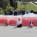 Skalbmierz. Mieszkańcy pozują do zdjęcia z prawie 30-metrową flagą / Karolina Kula