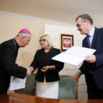 Urząd Stanu Cywilnego. Podpisanie porozumienia o współpracy dotyczącej organizowania pomocy materialnej dla ofiar wojny w Syrii oraz propagowania idei pokoju w świecie i unikania przemocy. Na zdjęciu: biskup Jan Piotrowski, Beata Kempa - minister i Wojciech Lubawski - prezydent Kielc  / Marzena Mąkosa / Radio Kielce