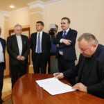 Urząd Stanu Cywilnego. Podpisanie porozumienia o współpracy dotyczącej organizowania pomocy materialnej dla ofiar wojny w Syrii oraz propagowania idei pokoju w świecie i unikania przemocy. Umowę podpisuje ks. profesor Waldemar Cisło / Marzena Mąkosa / Radio Kielce