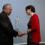 Finał akcji "Pola Nadziei". Ksiądz Stanisław Słowik - dyrektor Caritas Diecezji Kieleckiej wręcza „Anioła Nadziei z Żonkilem” Joannie Jaworskiej - nauczycielce ze Szkoły Podstawowej i Niepublicznego Gimnazjum w Brynicy / Marzena Mąkosa / Radio Kielce