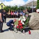 Jakubowice. Odsłonięcie popiersia Józefa Piłsudskiego. Kwiaty, w imieniu posła Andrzeja Kryja, składa Piotr Ślęzak z żoną, kandydat na burmistrza Ożarowa z PiS / Emilia Sitarska / Radio Kielce