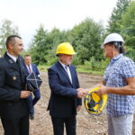 Wmurowanie kamienia węgielnego pod budowę OSP. Kamil Prędota - prezes OSP w Radkowicach i Andrzej Bętkowski - wicewojewoda świętokrzyski otrzymują kaski w celu wmurowania kamienia węgielnego / Marzena Mąkosa / Radio Kielce