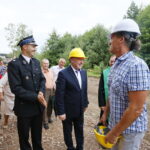 Wmurowanie kamienia węgielnego pod budowę OSP. Kamil Prędota - prezes OSP w Radkowicach i Andrzej Bętkowski - wicewojewoda świętokrzyski otrzymują kaski w celu wmurowania kamienia węgielnego / Marzena Mąkosa / Radio Kielce