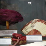 Promocja książki Edwarda Kusztala. Wystawa towarzysząca promocji książki. Na zdjęciu: kapelusz ze strusich piór oraz papierowy wachlarz / Marzena Mąkosa / Radio Kielce