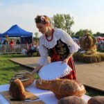 Dożynki powiatowe w Kazimierzy Wielkiej. Chleb przekazuje KGW Gunów Kolonia na ręce Łukasza Maderaka – zastępcy burmistrza Kazimierzy Wielkiej / Marta Gajda / Radio Kielce