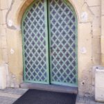 03.12.2019 Skalbmierz. Prace montażowe odnowionych metalowych drzwi w skalbmierskiej kolegiacie / ksiądz Marian Fatyga