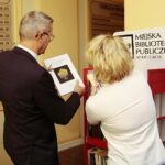 Kielce. 09.12.2019. Punkt do bookcrossingu w kieleckim ratuszu. Na zdjęciu (od lewej): Bogdan Wenta – prezydent miasta Kielce, Anna Żmudzińska - dyrektor Miejskiej Biblioteki Publicznej w Kielcach / Wiktor Taszłow / Radio Kielce