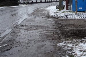 27.01.2021 Złotniki gmina Małogoszcz. Wjazd na plac budowy sklepu i zabrudzony chodnik / Ewa Pociejowska-Gawęda / Radio Kielce