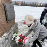 31.01.2021. Bilcza. Cmentarz parafialny. Dzieci z klasy III składają kwiaty i zapalają znicze pod tablicą poświęconą ks. Piotrowi Ściegiennemu / Kamil Król / Radio Kielce