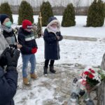 31.01.2021. Bilcza. Cmentarz parafialny. Dzieci z klasy III składają kwiaty i zapalają znicze pod tablicą poświęconą ks. Piotrowi Ściegiennemu / Kamil Król / Radio Kielce