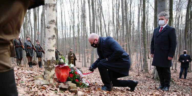 27.02.2021. Zgórsko. Złożenie wieńców i zniczy w miejscu ekshumacji Żołnierzy Wyklętych. Wieniec składają (od lewej): Rafał Nowak - wicewojewoda świętokrzyski i Krzysztof Słoń - senator  / Wiktor Taszłow / Radio Kielce