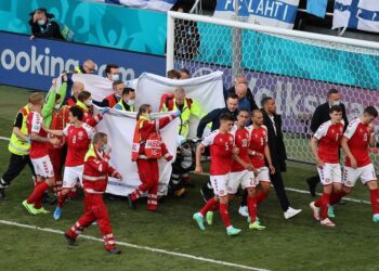 12.06.2021. Kopenhaga. Piłkarze Danii eskortują swojego kolegę z drużyny, Christiana Eriksena, po otrzymaniu pomocy medycznej podczas meczu rundy eliminacyjnej grupy B pomiędzy Danią i Finlandią UEFA EURO 2020 / PAP/EPA/Wolfgang Rattay / POOL