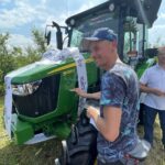 16.06.2021. Orłowiny. Przekazanie Radosławowi Gumińskiemu - zwycięzcy loterii Grupy Azoty nowoczesnego ciągnika. Na zdjęciu: Piotr Żyła podpisuje się na ciągniku / Emilia Sitarska / Radio Kielce