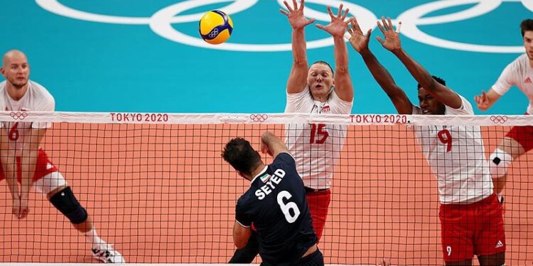 24.07.2021. Japonia. Tokio. Igrzyska Olimpijskie - Tokio 2020. Reprezentanci Polski Bartosz Kurek (z lewej), Jakub Kochanowski (w środku), Wilfredo Leon (drugi z prawej) i Aleksander Śliwka (z prawej) oraz Seyed Mohammad Mousavi Eraghi (drugi z lewej) z drużyny Iranu podczas pierwszego meczu turnieju siatkarzy w hali „Ariake Arena” / Leszek Szymański / PAP