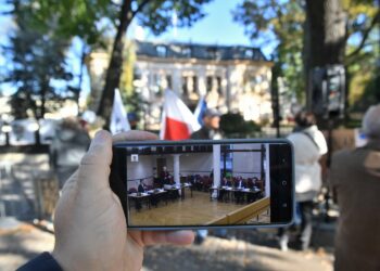07.2021. Warszawa. Obrady TK oglądane na ekranie telefonu na tle demonstracji przed siedzibą Trybunału Konstytucyjnego w Warszawie / Radek Pietruszka / PAP