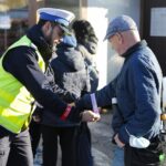 29.10.2021. Kielce. Akcja rozdawania odblasków przy kieleckim placu targowym. Na zdjęciu (po lewej): sierż. sztab. Tomasz Klimczewski - Komenda Miejska Policji w Kielcach / Wiktor Taszłow / Radio Kielce