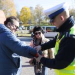 29.10.2021. Kielce. Akcja rozdawania odblasków przy Cmentarzu Starym. Na zdjęciu (po prawej): asp. Mateusz Wójcik - Komenda Miejska Policji w Kielcach / Wiktor Taszłow / Radio Kielce