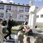 22.10.2021 Rykoszyn. Szkoła Podstawowa im. Józefa Piłsudskiego. Odsłonięcie pomnika Marszałka. Wieniec składa senator Krzysztof Słoń / Jarosław Kubalski / Radio Kielce