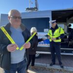 29.10.2021. Ostrowiec Świętokrzyski. Akcja rozdawania odblasków przy cmentarzu komunalnym. Na zdjęciu (po prawej): nadkom. Dominik Kowalski - naczelnik Wydziału Ruchu Drogowego Komendy Powiatowej Policji w Ostrowcu Świętokrzyskim / Emilia Sitarska / Radio Kielce