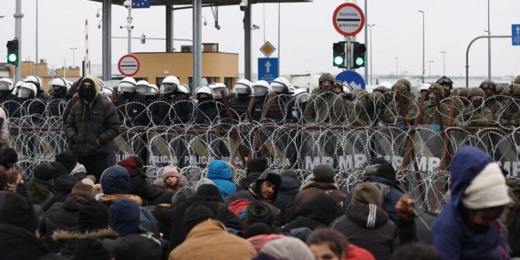 16.11.2021. Kuźnice. Osoby ubiegające się o azyl, uchodźcy i migranci, którzy przybyli na przejście graniczne białorusko-polskie Bruzgi-Kuźnicy Białostockiej, przełamali część barier  / EPA/OKSANA MANCHUK