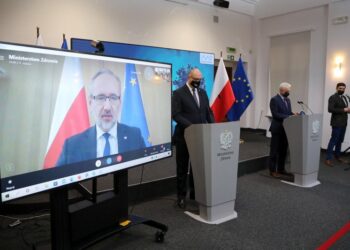 07.12.2021. Warszawa. Minister zdrowia Adam Niedzielski (na ekranie), wiceminister zdrowia Waldemar Kraska (z prawej) i Główny Inspektor Sanitarny wz. Krzysztof Saczka (z lewej) podczas konferencji prasowej w siedzibie Ministerstwa Zdrowia / PAP/Wojciech Olkuśnik