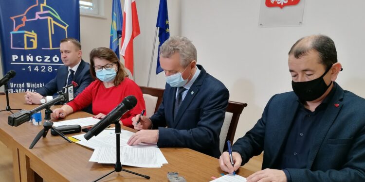 10.01.2022. Pińczów. Podpisanie umowy dotyczącej budowy kanalizacji w gminie Pińczów. Na zdjęciu (od lewej): minister Michał Cieślak, Mirosława Wiśniewska - skarbnik gminy Pińczów, Włodzimierz Badurak - burmistrz Pińczowa, Piotr Czyszczoń -  wykonawca zadania / Marta Gajda-Kruk / Radio Kielce