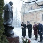 20.01.2022. Kielce. Złożenie kwiatów pod pomnikiem biskupa Czesława Kaczmarka. Na zdjęciu (od lewej): ks. Marcin Polak - wikariusz, ks. kan. dr Mirosław Cisowski - rzecznik kurii, Krzysztof Słoń - senator, Rafał Nowak - wicewojewoda świętokrzyski / Wiktor Taszłow / Radio Kielce