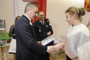 14.01.2022 Kielce. ŚUW. Finał konkursu "Pie(rw)szy na przejściu". Wojewoda Zbigniew Koniusz i nadinsp. Jarosław Kaleta wręczają dyplom dla Julii Iwan / Jarosław Kubalski / Radio Kielce