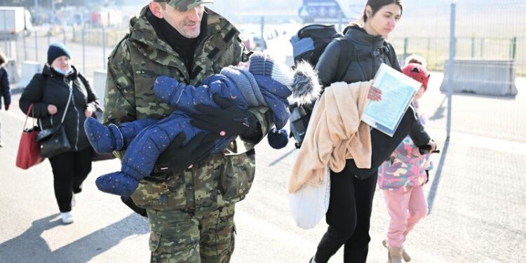 26.02.2022. Medyka. Sytuacja na przejściu granicznym w Medyce. Wiele osób, nie tylko z Polski, czeka na tych, którzy uciekają przed wojną z Ukrainy. Na samym przejściu widać głównie kobiety, które z małymi dziećmi na ręku szukają pomocy w naszym kraju / PAP/Darek Delmanowicz