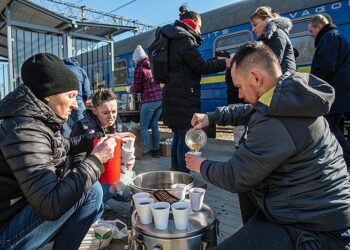 28.02.2022. Dorohusk. Wydawanie żywności dla uchodźców podróżujących pociągiem relacji Kijów - Warszawa na stacji kolejowej w Dorohusku / Wojtek Jargiło / PAP