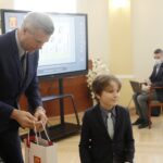 18.02.2022 Kielce. Wręczenie nagród i wyróżnień w konkursie plastycznym dla dzieci "Kielce- Moje Miasto w 2022 roku". Prezydent miasta Bogdan Wenta wręcza nagrodę Aleksandrowi Chańskiemu / Jarosław Kubalski / Radio Kielce