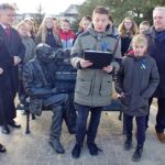 07.03.2022. Strawczyn. Odsłonięcie ławeczki Stefana Żeromskiego. Na zdjęciu (z lewej): Anna Krupka - wiceminister sportu i turystyki i senator Krzysztof Słoń; z prawej: Tadeusz Tkaczyk - wójt Strawczyna oraz uczniowie Szkoły Podstawowej im. Stefana Żeromskiego w Strawczynie / Marcin Marszałek / Radio Kielce