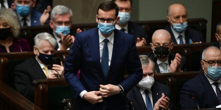 11.03.2022. Warszawa. Premier Mateusz Morawiecki (stoi) podczas uroczystego zgromadzenia posłów i senatorów na sali plenarnej Sejmu w Warszawie. Zgromadzenie Narodowe odbyło się w przededniu 23. rocznicy wstąpienia Polski do NATO / PAP/Marcin Obara